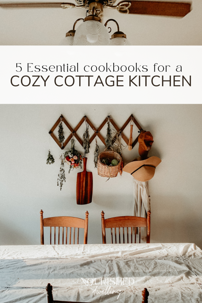 A Cozy Cottage Kitchen view of a linen set table and dried herbs and flowers hanging in site